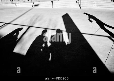 Menschen Silhouetten auf einem Gehsteig, schwarze und weiße Straße Foto. Stockfoto