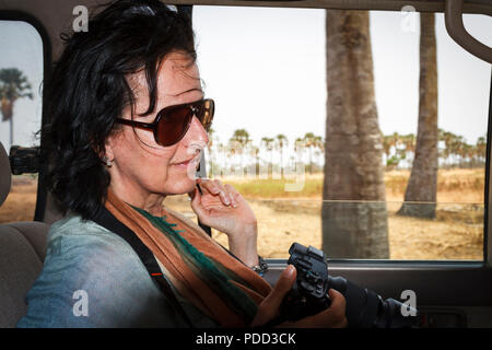 Senegal, Afrika - 24. April 2016: Frau auf Safari in Afrika in einem 4 Rad tauchen Auto bereit zum Aufnehmen von Bildern. Stockfoto