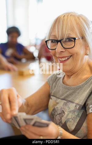 Portrait gerne ältere Frau Spielkarten im Community Center Stockfoto