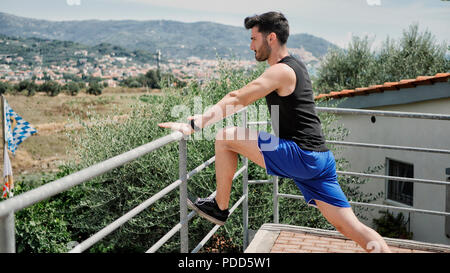 Junger Mann zu tun stretching Übung im Freien Stockfoto