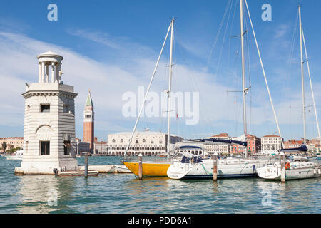 Yachten in der Marina San Giorgio Maggiore, Venedig, Venetien, Italien mit seinem Leuchtturm oder Rundumleuchte und Blick über die Lagune zum Dogenpalast ein Stockfoto