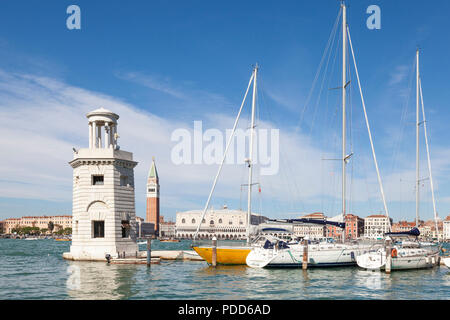 Yachten in der Marina San Giorgio Maggiore, Venedig, Venetien, Italien mit seinem Leuchtturm oder Rundumleuchte und Blick über die Lagune zum Dogenpalast ein Stockfoto