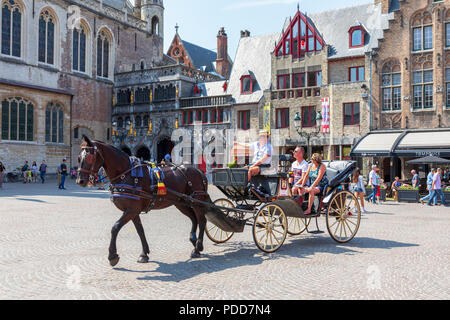 Touristen auf einer Stadtrundfahrt in einem Pferd und Trap, vorbei an den alten Gerichte, Burg, Brügge, Belgien Stockfoto