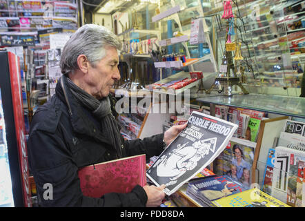 Januar 6, 2016 - Paris, Frankreich: Portrait von Ray Cosperec, der gerade die neueste Ausgabe von Charlie Hebdo gekauft mit einem mörderischen monotheistischen Gott auf dem Deckblatt. Gedenken de l'Sprengstoffanschlag contre Charlie Hebdo, un ein Apres l'attaque. *** Frankreich/KEINE VERKÄUFE IN DEN FRANZÖSISCHEN MEDIEN *** Stockfoto