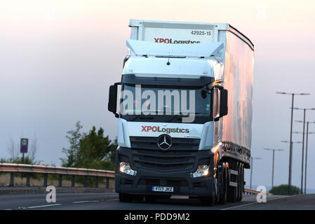 XPO Logistik Mercedes Actros Truck auf der zweispurigen Straße in der Dämmerung Stockfoto