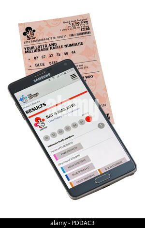 Smart Phone und Lottery Ticket isoliert auf einem weißen Hintergrund die Überprüfung von Ergebnissen Stockfoto