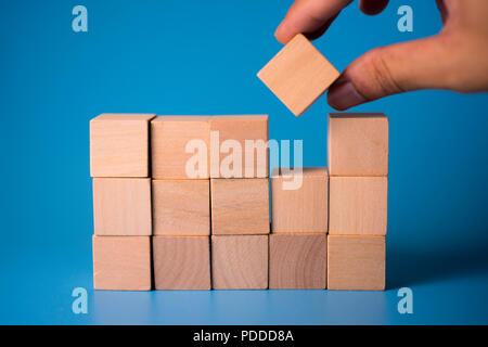 Hand auszufüllen quadratischen Holzblock in leeren Raum. Das Konzept der Erfüllung. Stockfoto