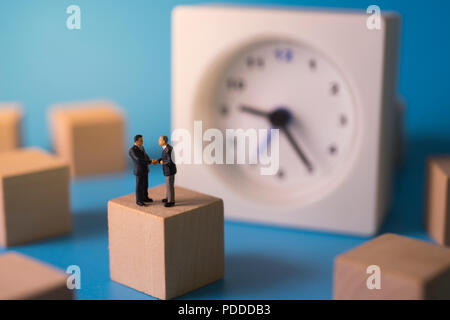 Geschäftsmann Hand schütteln mit Uhr Hintergrund. Business Konzept der Partnerschaft oder Vertrag. Stockfoto
