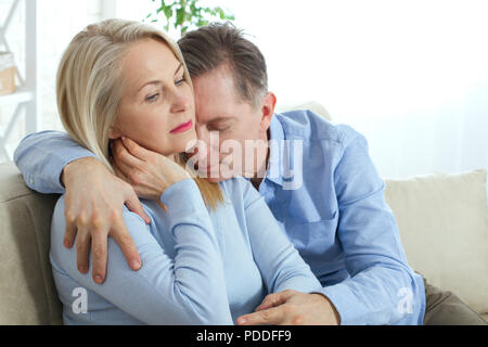 Nahaufnahme der fröhlichen Happy glücklich Glücklich, aufgeregt mit toothy strahlenden Lächeln blond attraktive Frau und Mann, er umarmt sie von hinten und Küsse Stockfoto