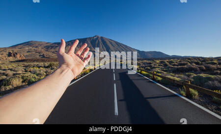 Gerade asphaltierte Straße mit Hand, die auf die Spitze des Pico del Teide Vulkan einladen. Nationalpark Teide, Teneriffa, Kanarische Inseln, Spanien. Stockfoto