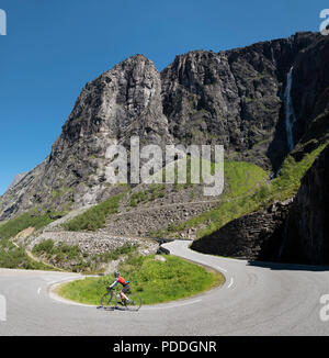 Weibliche Radfahrer auf einer Haarnadelkurve absteigend der berühmten Trollstigen Pass, Norwegen Stockfoto