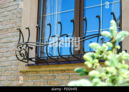 Braun Fenster mit stilisierten geschmiedeten Eisen bars Stockfoto