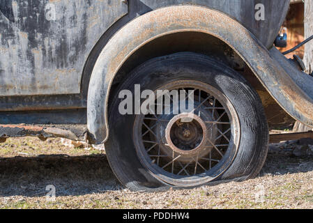 Die flachen hinteren Reifen (Reifen) und Speichenrad eines 1931 Studebaker Rockne in der Stadt Hill End in der Region New South Wales, Australien Stockfoto