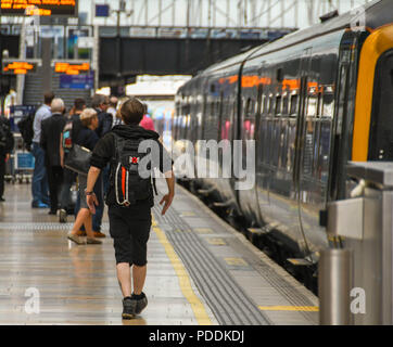 Junge Person entlang eine Plattform in London Paddington Bahnhof einen Zug zu bekommen Stockfoto