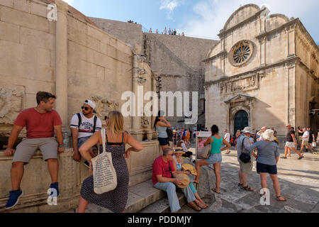 Touristen auf der großen Onofrio-brunnen in Dubrovnik, Kroatien, Europa sitzen Stockfoto