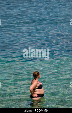 Übergewichtige Frau am Strand Stockfoto