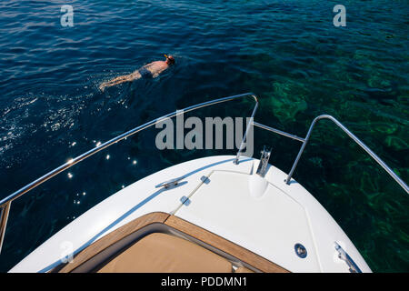 Man Schnorcheln in der Nähe einer Yacht Stockfoto