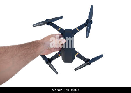 Mann hält eine kleine Drohne in der Hand auf weißem Hintergrund Stockfoto