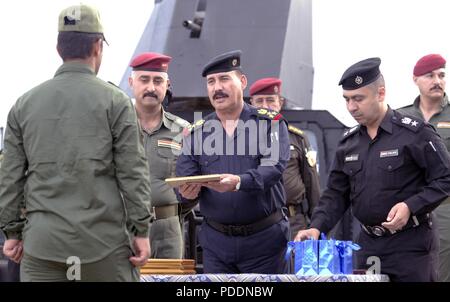 Ein Besuch Brigadegeneral mit irakischen Special Operations Forces präsentiert eine graduierte Mossul SWAT Student mit seiner Diplomarbeit bei einer Preisverleihung in Mossul, Irak, 13. Mai 2018. Mosul SWAT intensiv sowohl mit den Irakischen und Koalition Special Operations Forces, einer der Premiere kämpfende Einheiten besiegen ISIS werden geschult. Mosul SWAT ist das Fundament für die Zukunft des Irak durch die Verbesserung ihrer Fähigkeiten, um ein sicheres und stabiles Umfeld für ihre Nation zu stellen. Stockfoto