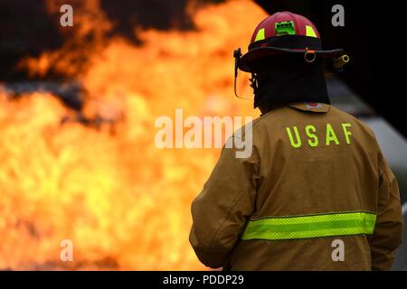 Eine US-amerikanische Flieger auf der 51. Bauingenieur Squadron Feuerwehr- und Rettungsdienste Flug zugewiesene beobachtet, wie der US Air Force und die Südkoreanischen Feuerwehrmänner bekämpfen einen Brand simuliert Flugzeuge während einer Übung auf der koreanischen nationalen Universität von Wohlfahrt in Pyeongtaek, Republik Korea, 17. Mai 2018. Eine solche Ausbildung Möglichkeiten profitieren Flieger und es ihnen zu ermöglichen, aus erster Hand zu erleben, wie es ist, neben ausländischen Service Mitglieder zu arbeiten, und zu erfahren, wie alle Sprachbarrieren zu überwinden. Stockfoto