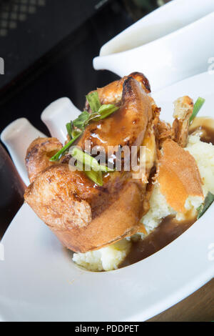 Ein englisches Pub/Restaurant Dish einzelner Kröte in die Bohrung auf einem Bett aus Kartoffelpüree mit Rich brown gravy Sauce serviert. Stockfoto