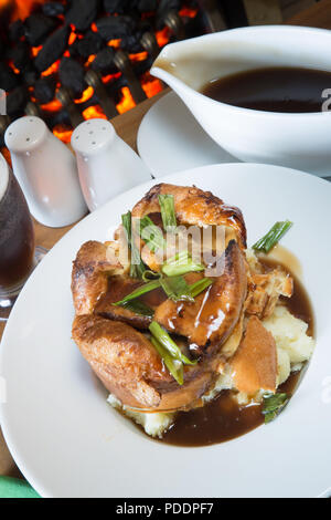 Ein englisches Pub/Restaurant Dish einzelner Kröte in die Bohrung auf einem Bett aus Kartoffelpüree mit Rich brown gravy Sauce serviert. Stockfoto