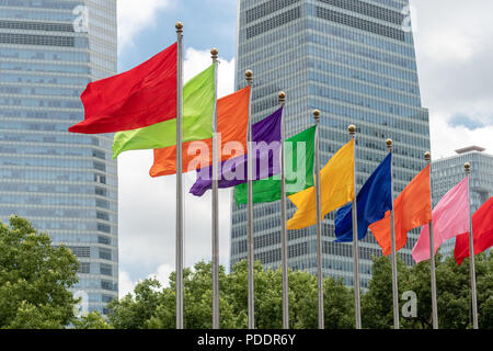 Verschiedene einfarbige Fahnen von einer Reihe der flag Pole in Shanghai, China fliegen Stockfoto
