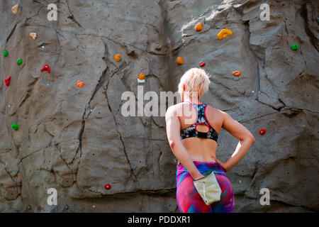 Foto von der Rückseite der sportlichen Frau Kletterer mit Tasche von Seife gegen rock Boulder Stockfoto