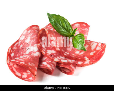 Salami in Scheiben geschnitten. Roh geräucherter Wurst Schichten auf weißem Hintergrund. Einige Stücke oder mehrere Schichten. Seitliche Sicht auf vier Stück roh geräucherter Wurst mit Basilikum Blatt auf Weiß mit Freistellungspfad isoliert Stockfoto