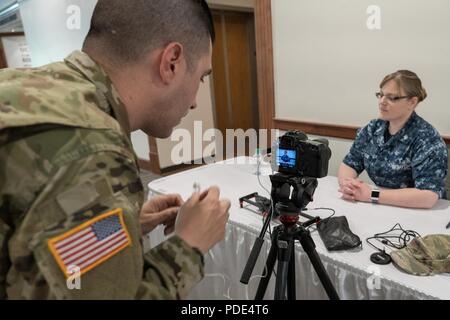 Us-Armee Sgt. Paul Thorson, 101 Öffentliche Angelegenheiten Loslösung, Alabama Army National Guard, Interviews Hospital Corpsman 1. Klasse Amie Mclean im Betrieb Stärken Gesundheit größere Savannah, 12. Mai 2018 in Savannah, Georgia. Mclean anerkannten Nachweis für hohen Blutdruck und medizinische Behandlung für einen Patienten, der auf eine optische Prüfung war. Stockfoto