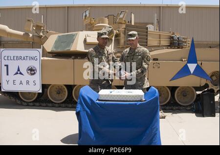 Us-Armee Oberstleutnant Craig Martin, Commander, Task Force Battle, Betrieb inhärenten lösen kann, und der Befehl "Sgt. Maj. Louis De Leon, Task Force Battle Sgt. Maj., bereiten einen Kuchen Markierung des III Korps 100 Jahr Jubiläum zu schneiden, 16. Mai 2018, im Camp Arifjan, Kuwait. Die III Korps wurde während des Zweiten Weltkrieges organisierte ich, am 16. Mai 1918, in Frankreich. Es war der dritte von vier neue Corps aktiviert Alliierten Kräfte wie die American Expeditionary Force im Kampf gegen die Mittelmächte in Europa unterstützen. Stockfoto