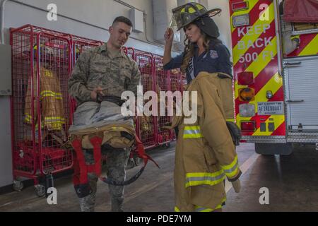 Airman 1st Class Austin Nash, ein Feuerwehrmann der Feuerwehr in Barksdale Air Force Base in Louisiana zugewiesen, zeigt Logan Lester, Fräulein Texas USA 2018, Brandbekämpfung Gang während Lester's Besuch in Barksdale mit anderen Kandidaten im Jahr 2018 Miss USA Pageant, 15. Mai 2018. Feuerwehrmänner angezeigt, Feuerlöscheinrichtungen und Feuerwehrautos während des Wettbewerbsteilnehmers tour. Stockfoto