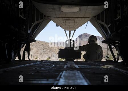 Us Marine Corps Staff Sgt. Joel Asher beobachtet das Gelände von der Rückseite eines CH-53E Super Stallion während integrierte Ausbildung Übung (ITX) 3-18 an Bord Marine Corps Air Ground Combat Center, Twentynine Palms, Calif., 18. Mai 2018. ITX ist ein groß angelegtes, kombiniert - arme Training Übung zur Bekämpfung bereit Kräfte in der Lage, die als integrierte Marine Air-Task Force zu produzieren. Asser ist ein helicopter Crew Chief mit Marine schweren Helikopter Squadron 464. Stockfoto