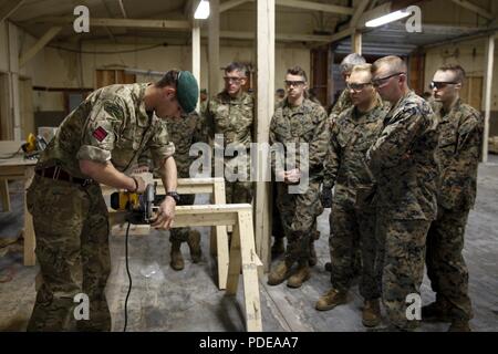 Britische Armee Spr. Mark R. Maton, Commando mit 131 Commando Squadron Royal Engineers, britische Armee, lehrt Marines mit 6. Techniker Bataillon, 4. Marine Logistik Gruppe, und British Commando mit 131 Commando Schwadron RE, britische Armee, wie eine Kreissäge Power Tool auf einer Baustelle während der Übung rote Dolch am Fort Indiantown Gap, Pa, 19. Mai 2018. Übung rote Dolch ist eine bilaterale Übung, die Marines die Möglichkeit, Taktiken, Techniken und Verfahren sowie Aufbau von Arbeitsbeziehungen mit ihren britischen Kollegen. Stockfoto