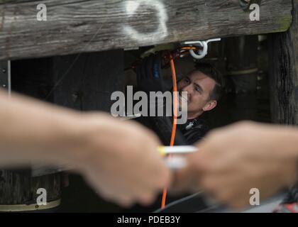 Strand, Virginia (18. Mai 2017) Builder zweiter Klasse Steven Balsavich, eine Marine Taucher unterwasser Bau Team angeschlossen, verwendet einen Bohrer in das Wasser in der Nähe von Pier 6 auf gemeinsamen Expeditionary Base wenig Creek-Fort Story, 18. Mai 2018. Der Hafen Verbesserung über anspruchsvolle Reparatur (PIER) Gemeinsame Fähigkeit Technology Demonstration (JCTD) bietet einen umfassenden Ansatz zur expeditionary Reparatur von Pier Einrichtungen einen lang anhaltenden, Upgrade auf eine bestehende Anlage zu erreichen und bietet eine weitere Möglichkeit, wie der Schiffbau Kraft führt port Schäden reparieren. Stockfoto