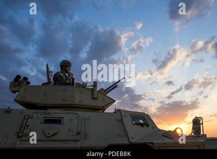 Spc. Jake Tatge, ein US Army Reserve Militärpolizei Soldat mit dem 346 MP Unternehmen, stellt für ein Portrait auf einen gepanzerten Fahrzeug Sicherheit bei Sonnenuntergang in Fort Riley, Kansas, 18. Mai 2018. Die 346 MP Firma gehostet und führte eine 3-Wochen schießwesen Ausbildung und Reichweite für ca. 30 fahrzeugbesatzungen Tag und Nacht auf und Crew zu qualifizieren dienen Waffen, mit der die M 2. 50-Kaliber Maschinenpistole, die M240B Maschinengewehr, die MK19 Granatwerfer und die Gemeinsame ferngesteuert betrieben Waffenstation (Krähen) in Fort Riley, Kansas, Mai 3-22, 2018. Soldaten aus der 603Rd MP Unternehmen nahmen ebenfalls an der Stockfoto