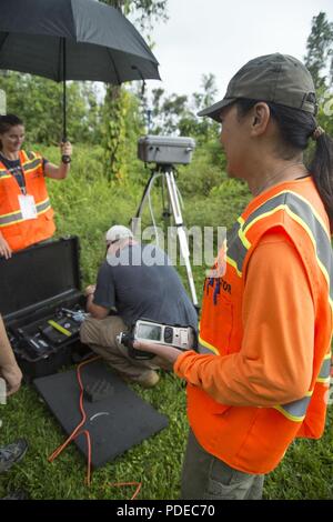 Pāhoa, Hawaii, 20. Mai 2018 - US Environmental Protection Agency (EPA) Auftragnehmer Wilson Yee Tests die Menge an Schwefeldioxid in der Luft in dem schwarzen Sand Nachbarschaft von der Kīlauea Vulkanausbruch betroffen, während seine Mannschaft installiert einen temporären Überwachung der Luft entfernt. Als Teil eines FEMA-Mission - Zuordnung, EPA arbeiten mit dem Hawaii Abteilung der Gesundheit ist Bewohnern zu helfen, sicher durch die Installation von Air Monitoring Stationen, die Daten über Schwefeldioxid, Schwefelwasserstoff zur Verfügung halten, und die partikelwerte. Stockfoto