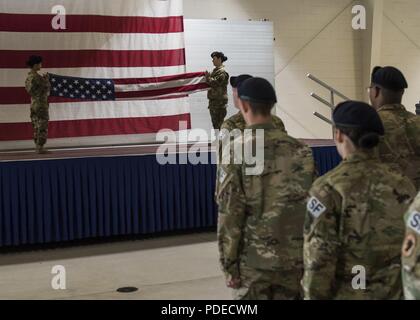 Team Minot Sicherheitskräfte Flieger eine Flagge während der Polizei Woche retreat Zeremonie am Minot Air Force Base, Virginia, 17. Mai 2018. Die Zeremonie würdigte alle Militär- und Vollzugsbeamten, die das ultimative Opfer im Laufe der Jahre bezahlt haben. Stockfoto