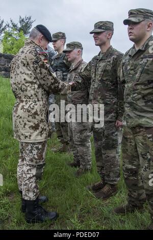 Us-Armee SPC. Nicholas Rossetti, ein Musiker auf der 39th Army Band, New Hampshire Army National Guard zugewiesen, erhält die Bundeswehr Proficiency Abzeichen (GAFPB) von der Deutschen Armee Oberstleutnant Michael Breuer, der Deutschen Verbindungsoffizier zur United States Military Academy, in der Region 1 am besten Krieger Wettbewerb in West Point, New York, 19. Mai 2018. Der Wettbewerb, Mai 16-19, 2018, ist eine jährliche Veranstaltung, in der Junior Soldaten und Unteroffiziere (NCOs) von acht nordöstlichen Staaten Soldaten konkurrieren in mehreren Veranstaltungen bestimmt sind, ihre militärischen Fähigkeiten und Kenntnisse zu prüfen, wie Stockfoto