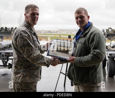 Us Air Force Colonel Mathew Powell, Kommandant der 3. Wartung Gruppe, präsentiert Staff Sgt. Brandon Ford mit den Waffen Supervisor des Quartals Award nach dem Flügel Waffen laden Crew 1. Quartal Wettbewerb Mai 18, 2018, Joint Base Elmendorf-Richardson, Alaska. Die vierteljährlichen Wettbewerb besteht aus zwei AMU Waffen - Abschnitt teams Kopf an Kopf für Zeit und Genauigkeit. Stockfoto