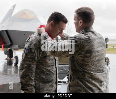 .S. Air Force Colonel Mathew Powell, Kommandant der 3. Gruppe Orte eines Gewinners Medaille auf Staff Sgt. Randall Stoiner nach dem Flügel Waffen laden Crew 1. Quartal Wettbewerb Mai 18, 2018, Joint Base Elmendorf-Richardson, Alaska. Eine Waffen laden Crew ist eine Gruppe von drei Personen verantwortlich für die Vorbereitung und Laden von Munition in ein Luftfahrzeug. Stoiner war das Team Chief 90 Aircraft Maintenance Unit Waffen Abschnitt. Stockfoto