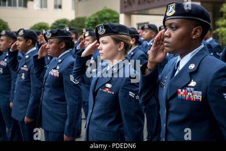 Flieger an die 374 Sicherheitskräfte Squadron salute während dem Spielen der Nationalhymne während Polizei Woche Gedenkfeier, 18. Mai 2018, bei Yokota Air Base, Japan zugeordnet. Nationale Polizei Woche besondere Anerkennung an die Vollzugsbeamten, die ihr Leben im Dienst für die Sicherheit und den Schutz von anderen verloren haben. Stockfoto