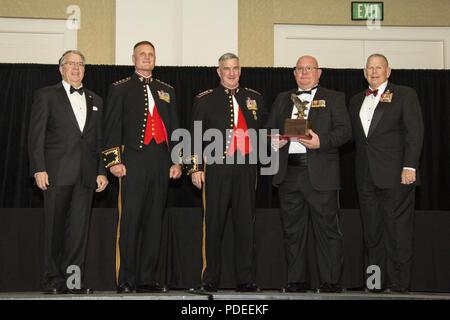 Der stellvertretende Kommandant des Marine Corps Gen. Glenn M. Walters, Mitte, präsentiert die Robert F. Gibson Award für Marine Air Command und Control Officer des Jahres zum Vater der Kapitän Steven E. Nye, zweiter von rechts, Tactical Air Operations Center detachment Commander, Marine Air Control Squadron 4 (MACS-4), Marine Air Control Group (MACG-18) im Namen der Kapitän Nye während des 47. jährlichen Marine Corps Aviation Association (MCE) Symposium und Preisbankett, San Diego, Calif., 18. Mai 2018. Walters war der Gastredner für die Veranstaltung und präsentiert 13 Einheit 16 individuelle Preise und Auszeichnungen Stockfoto