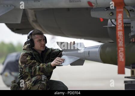 Flieger mit den 180 Fighter Wing Instandhaltungsgruppe verwendet eine Bombe Anheben eines MK-82 Allgemeine Bombe auf einem F-16 Fighting Falcon bei einem Training am 19. Mai 2018 zu laden. Flieger trug Mission-Oriented Persönliche Schutzausrüstung und gleichzeitig, Starten und Wiederherstellen von Flugzeugen, die in ein Umfeld, in dem die chemischen Angriff simulieren. Stockfoto