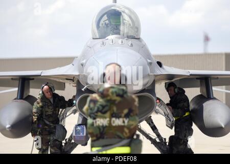 Flieger mit den 180 Fighter Wing Instandhaltungsgruppe verwendet Hand signalisiert eine F-16 Fighting Falcon bei einem Training am 19. Mai 2018. Flieger trug Mission-Oriented Persönliche Schutzausrüstung und gleichzeitig, Starten und Wiederherstellen von Flugzeugen, die in ein Umfeld, in dem die chemischen Angriff simulieren. Stockfoto