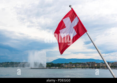 Flagge der Schweiz fliegen aus der Pole auf Pont du Mont Blanc mit dem Jet d'Eau im Hintergrund Stockfoto