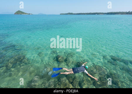 Touristen schnorcheln im kristallklaren türkisblauen Wasser in der Nähe von Tropical Resort in Phuket, Thailand. Sommer, Ferien, Reisen und Urlaub. Stockfoto