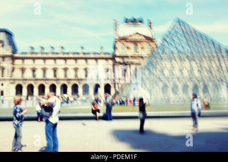 Touristen auf dem Platz des Louvre in Paris an einem sonnigen Frühlingstag. Verschwommen Stockfoto