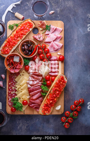 Salami, Schinken, Wurst, Schinken, Käse, Tomaten. Fleisch Antipasti am Tisch aus Stein. Ansicht von oben mit der Kopie. Stockfoto