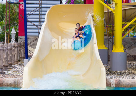 PHUKET, Thailand - 8. Juli 2017 - Asiatische weibliche Jugendliche nach unten schieben, Wasser Schieberegler auf Doppel Floater bei Splash Jungle Water Park in Phuket, Thailand auf J Stockfoto